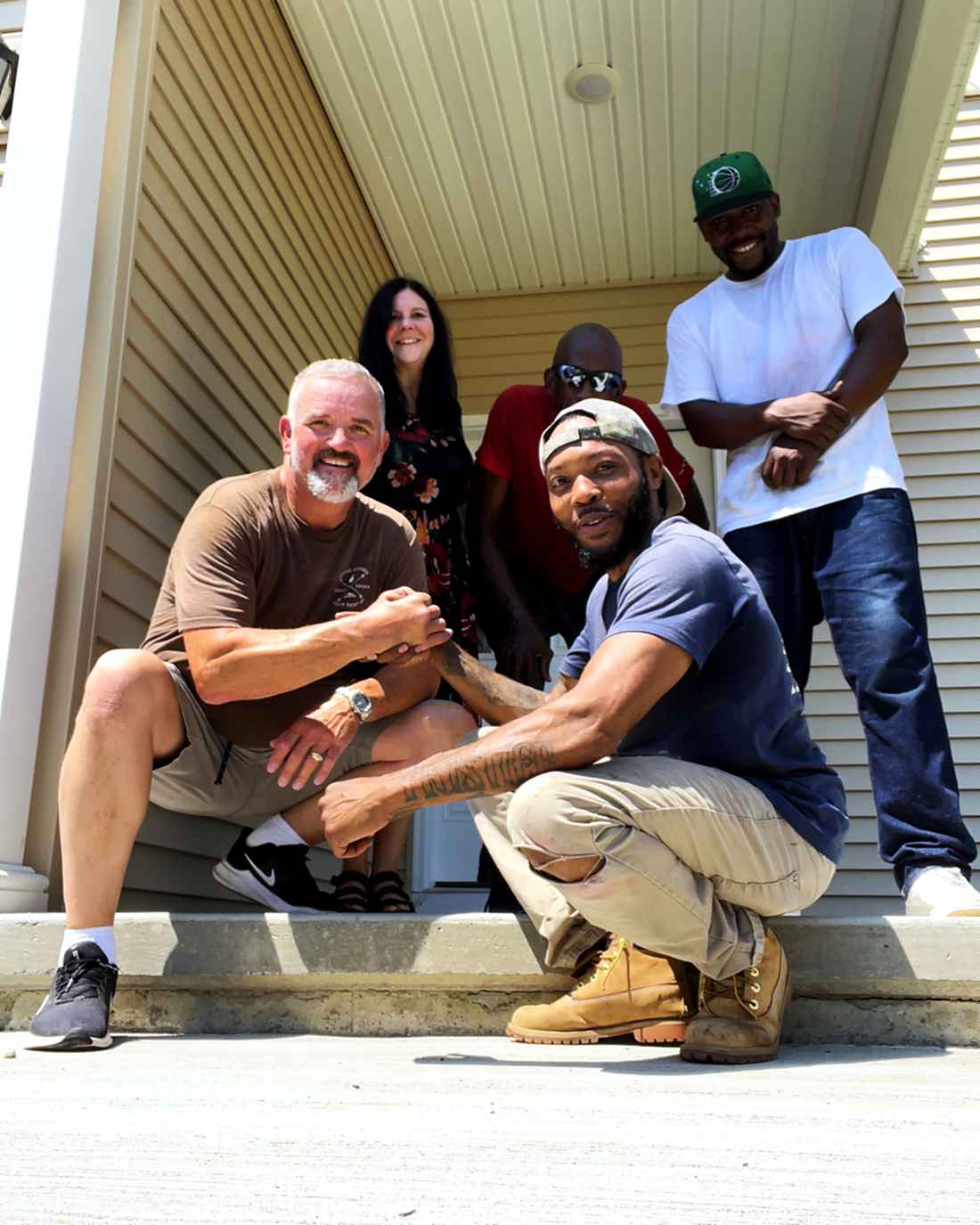 A moving crew and the customers together on the front steps at the end of a job